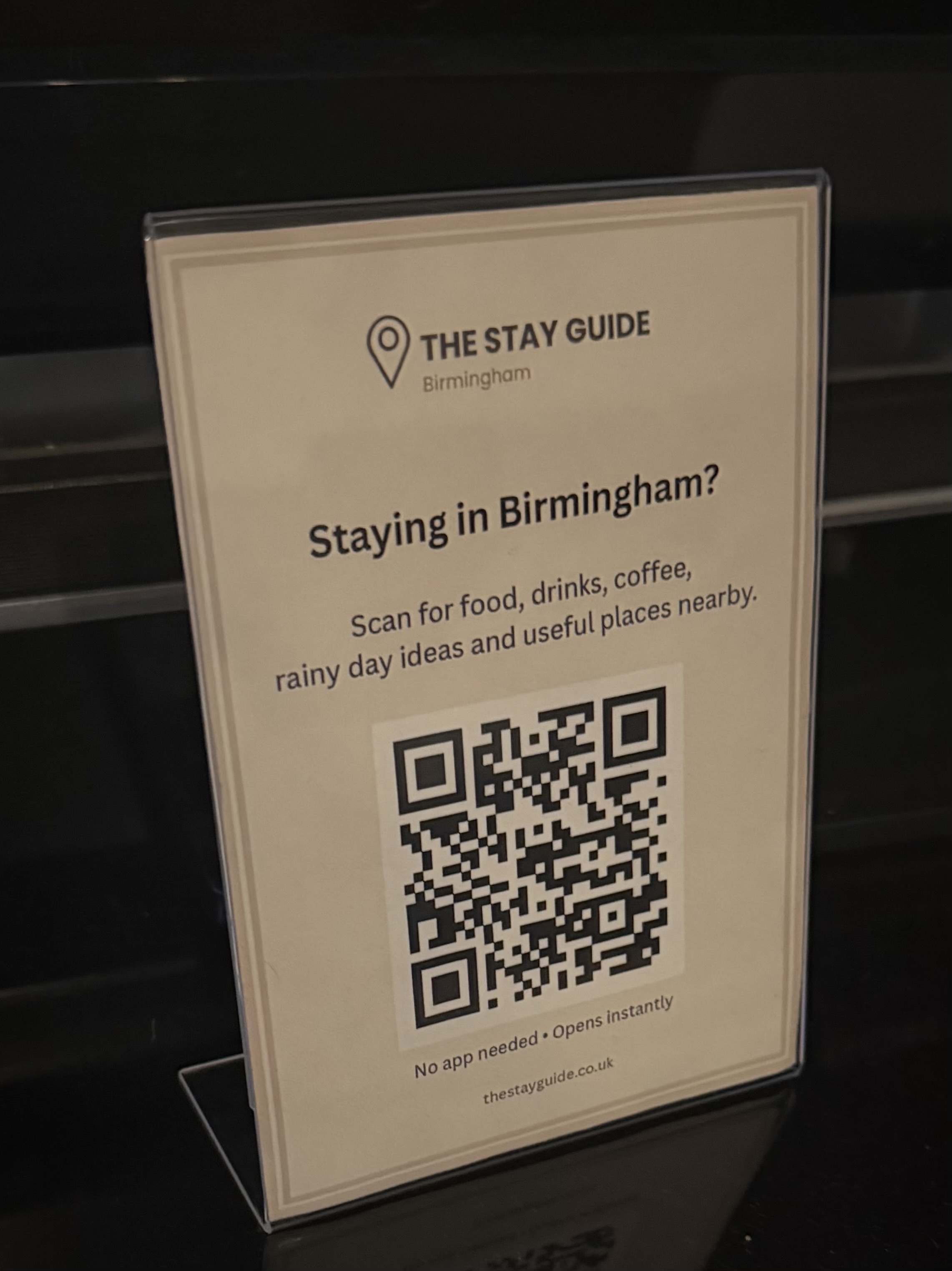 The Stay Guide Birmingham QR guest card in an acrylic display stand